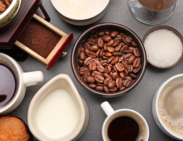 coffee beans surrounded by mugs